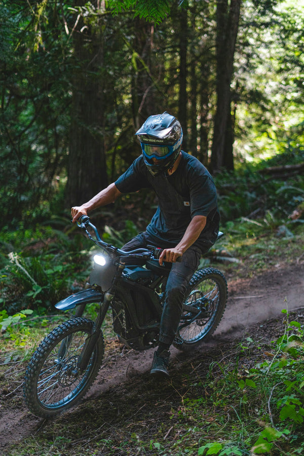 Rider on an electric dirt bike on a forest trail